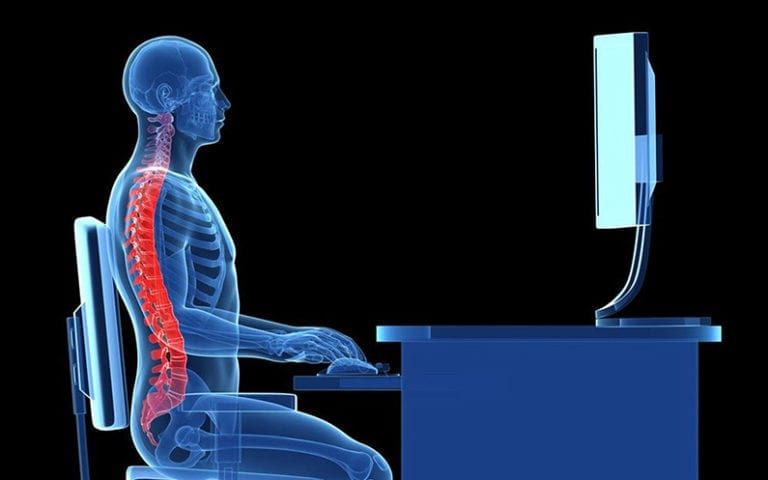 A digital illustration shows a transparent human figure with visible bones and spine sitting upright at a desk, typing on a keyboard while facing a computer monitor.