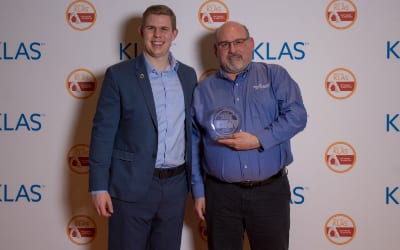Greg Wentz accepts Practice Velocity's KLAS Category Leader Award from Jackson Tate
