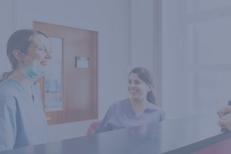 two happy healthcare workers in scrubs laughing