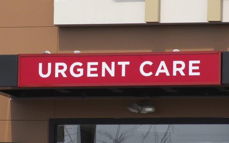 A red and white sign above a building entrance reads "URGENT CARE.
