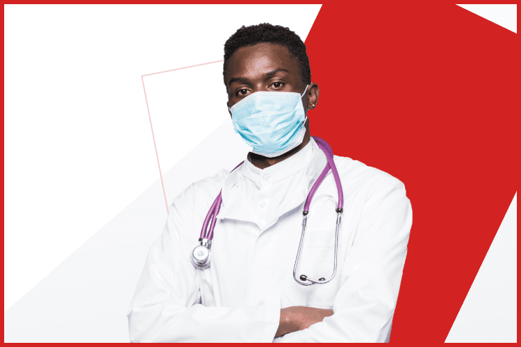 A male doctor wearing a face mask and white coat with a stethoscope around his neck, standing with arms crossed against a red and white background.