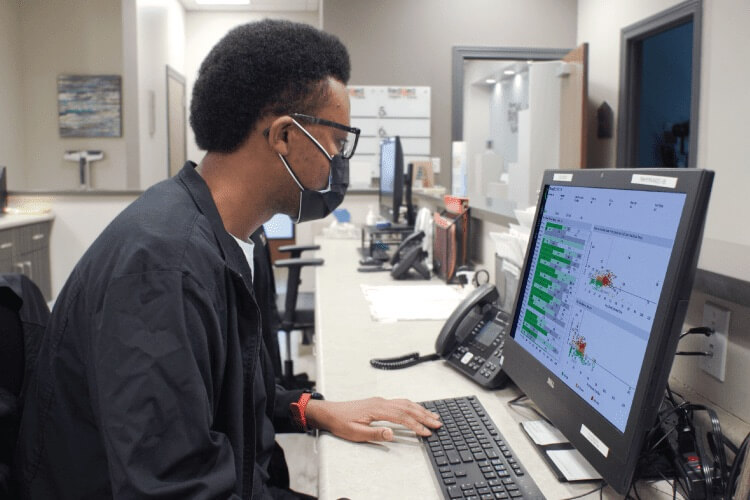 healthcare professional reviewing data on a desktop computer