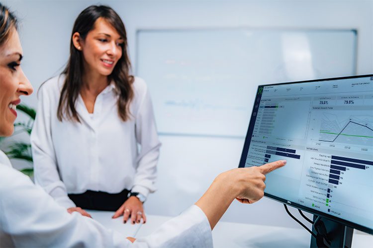 Doctor pointing at a computer screen while a patient looks on.