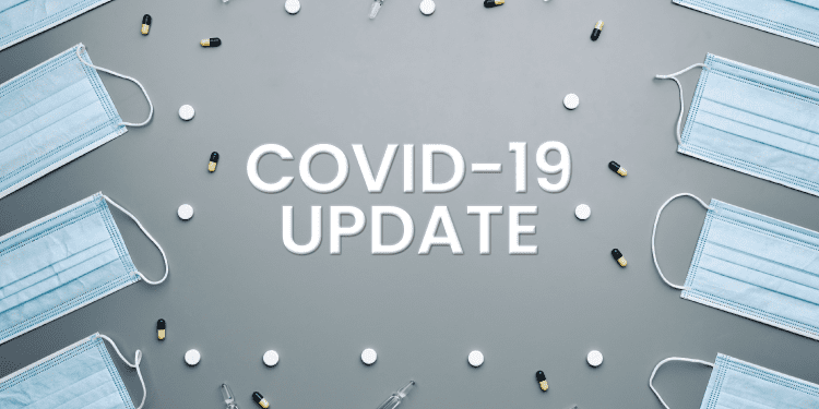 Grey background with text "COVID-19 UPDATE" surrounded by blue surgical masks, white round pills, black and yellow capsules, and small glass vials.