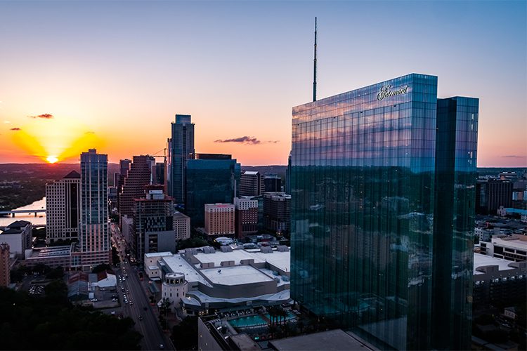 Drone-like photograph of Austin's Fairmont Hotel building at sunset