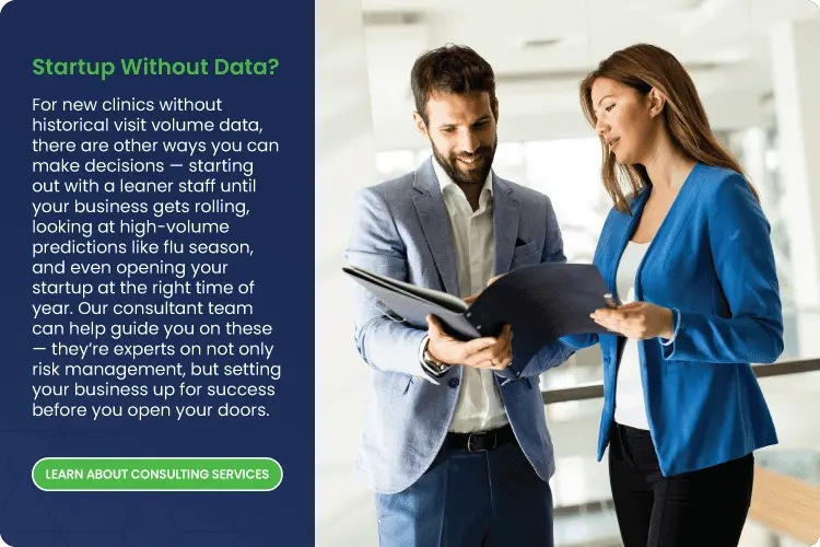 two urgent care professionals reviewing a binder of data