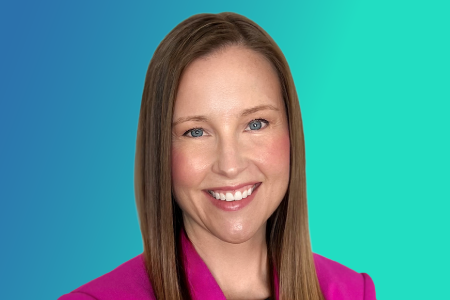 Woman with straight light brown hair, wearing a bright pink blazer, smiling at the camera. The background is a gradient of blue and teal, reminiscent of calm often sought in urgent care settings—a subtle nod to the peak end rule in patient experiences.